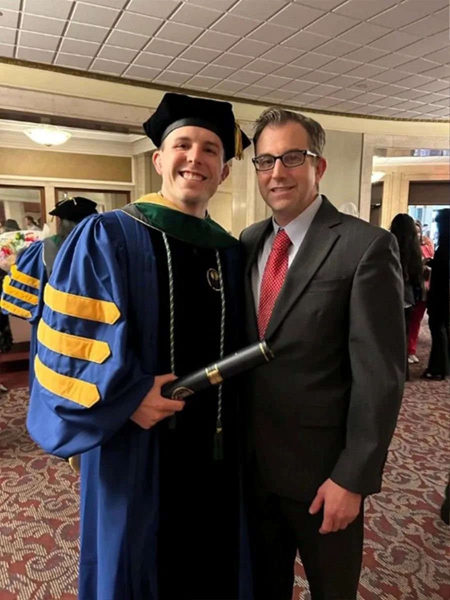 Dr. David Provenzano with a graduate in academic robes