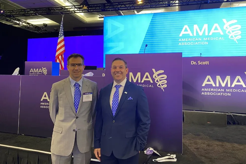 Dr. David Provenzano and a colleague in front of American Medical Association signs
