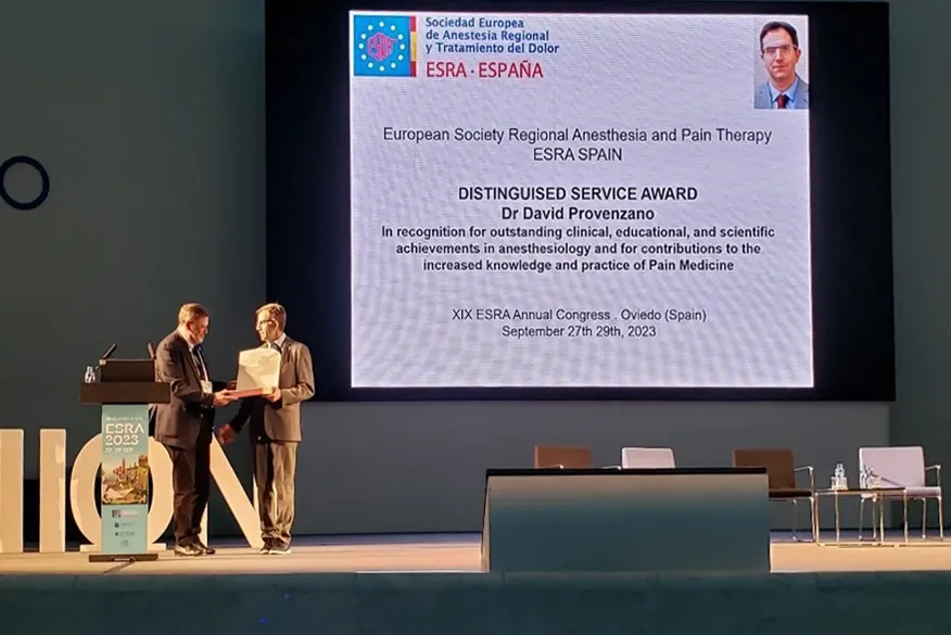 Dr. David Provenzano receiving the ESRA Spain Distinguished Service Award on stage