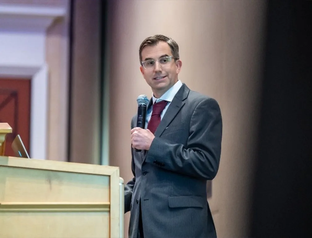 Dr. David Provenzano speaking into a microphone beside a podium