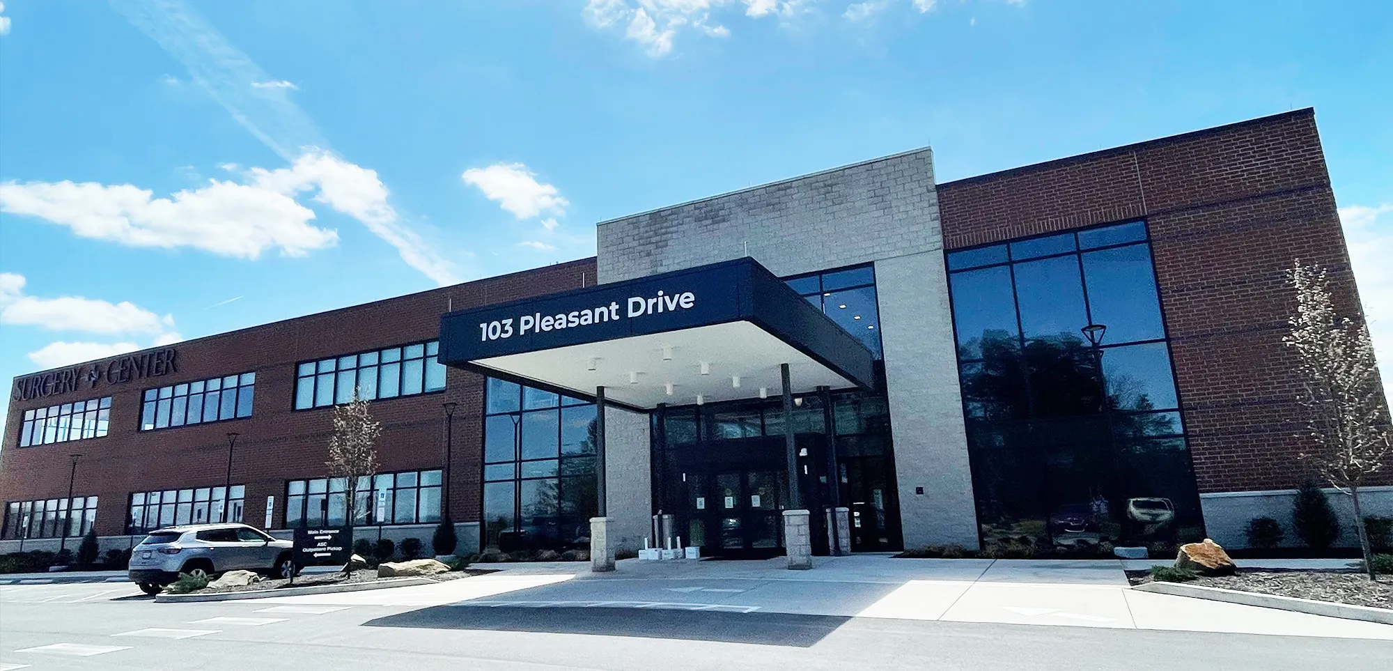 Front of a brick and glass building with a 103 Pleasant Drive sign over the entrance