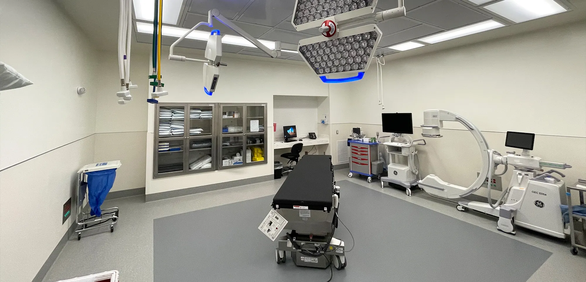 Operating room with a procedure table, an X-ray machine and surgical lights